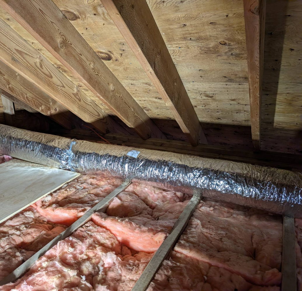 Insulated bathroom exhaust duct supported along attic framing on its run to the exterior